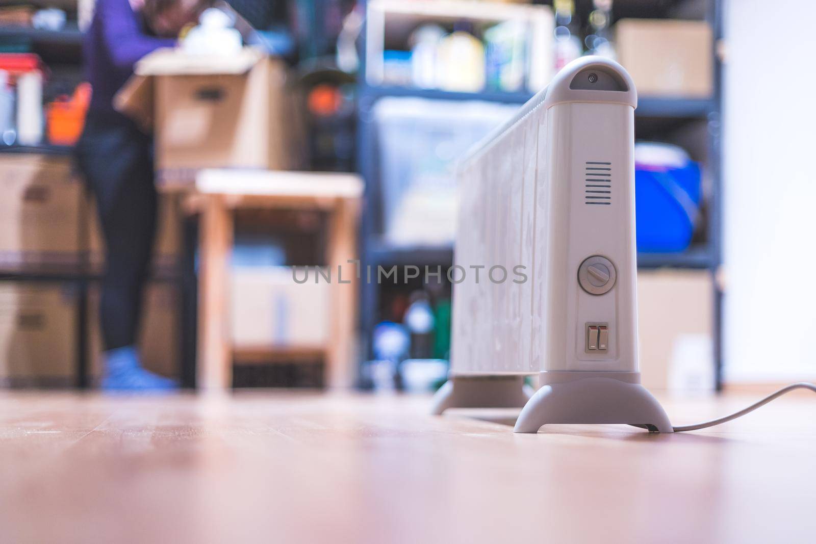 Electric heater, heating the basement. Blurry shelfs in the background
