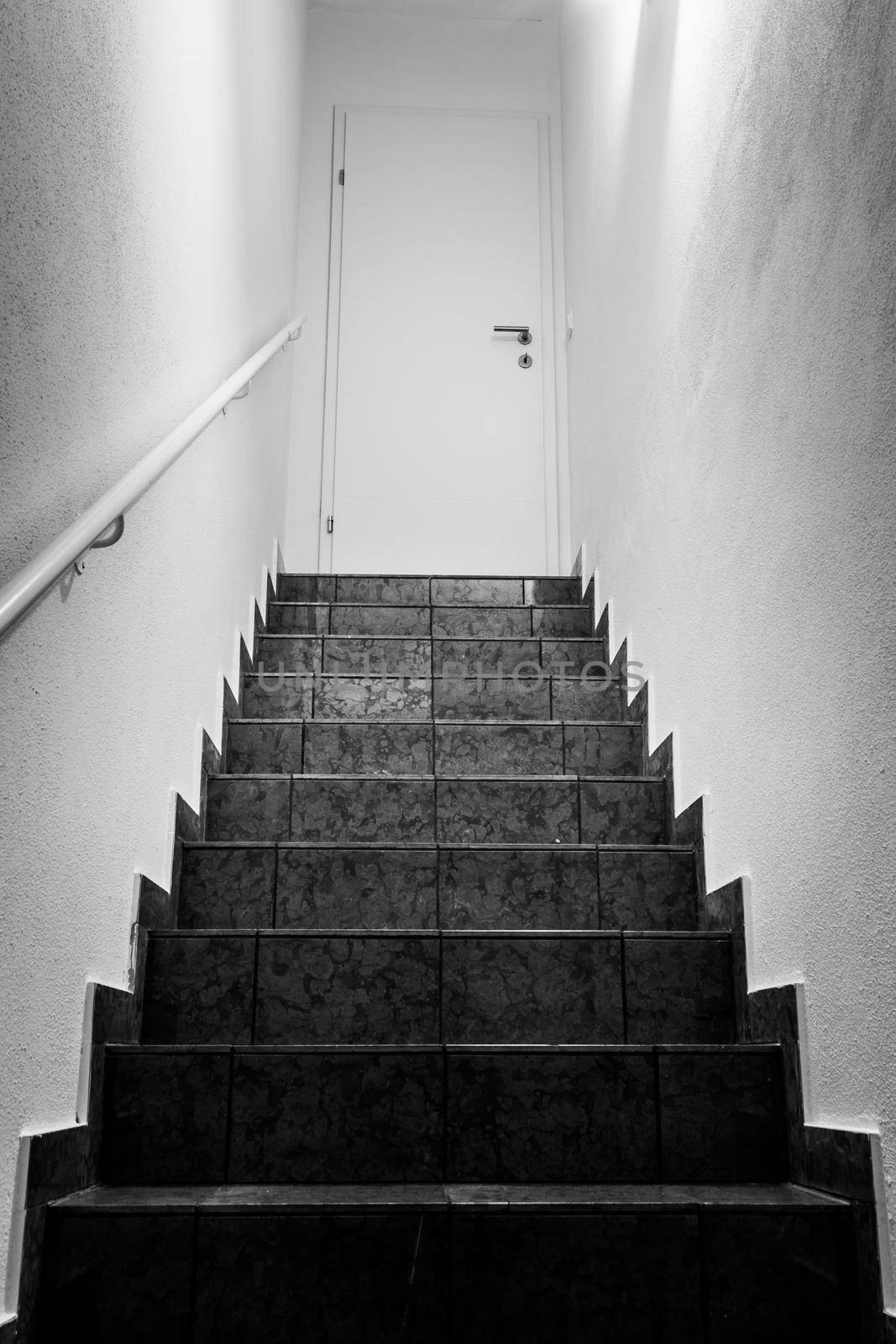 Basement stairs with balustrade, closed white door