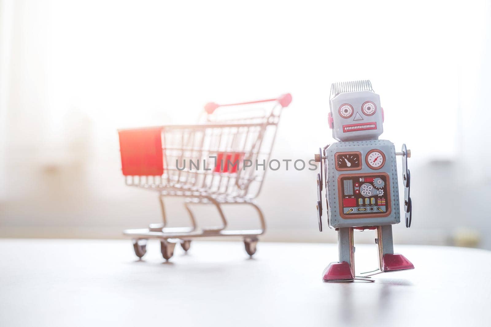 Online-Shopping concept: Toy robot and Miniature shopping cart