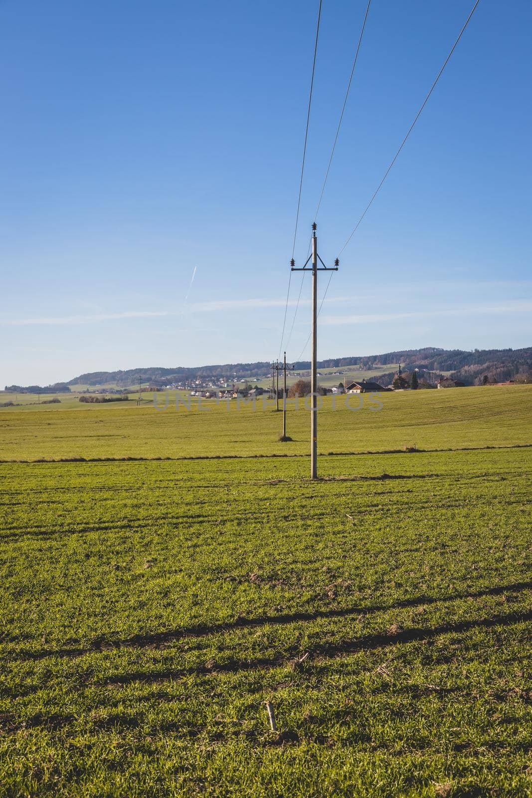 Green grass field with high voltage line in summer, nobody, wideness by Daxenbichler