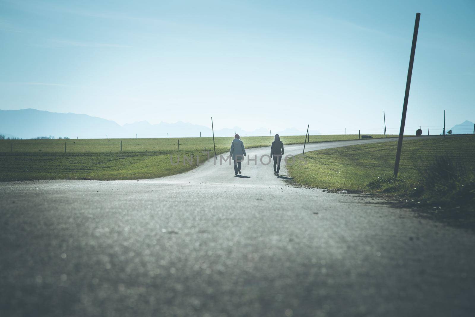 Two people are walking on an abandoned road