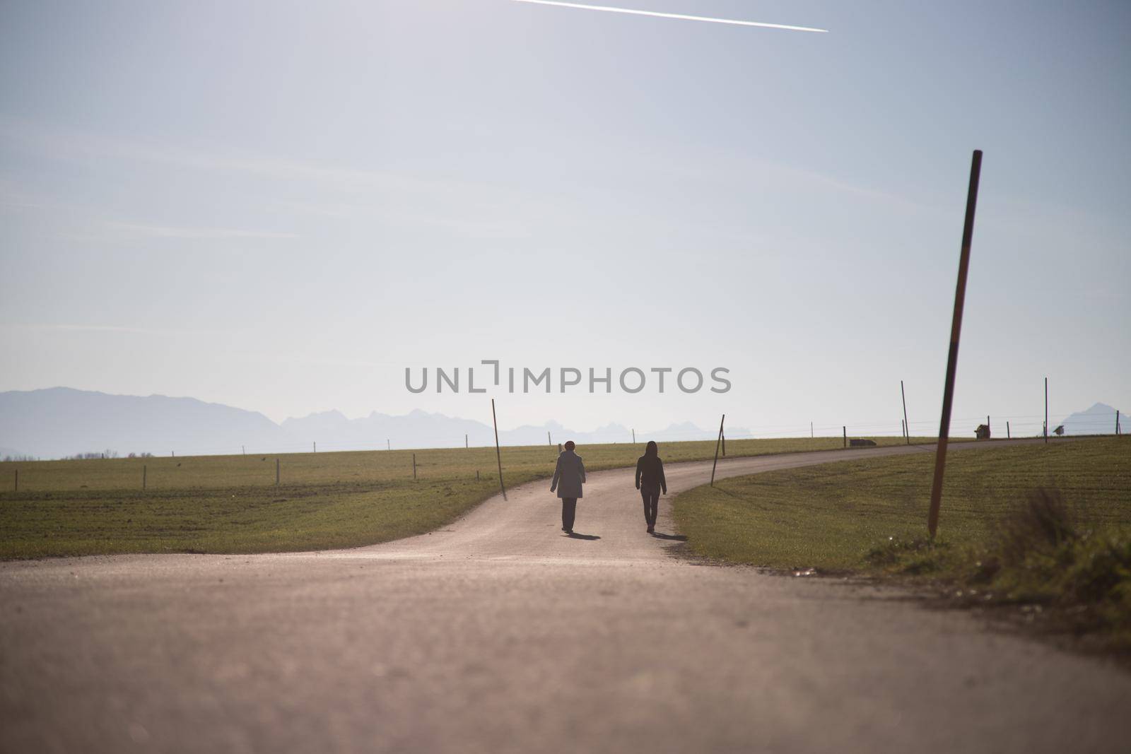 Two people are walking on an abandoned road
