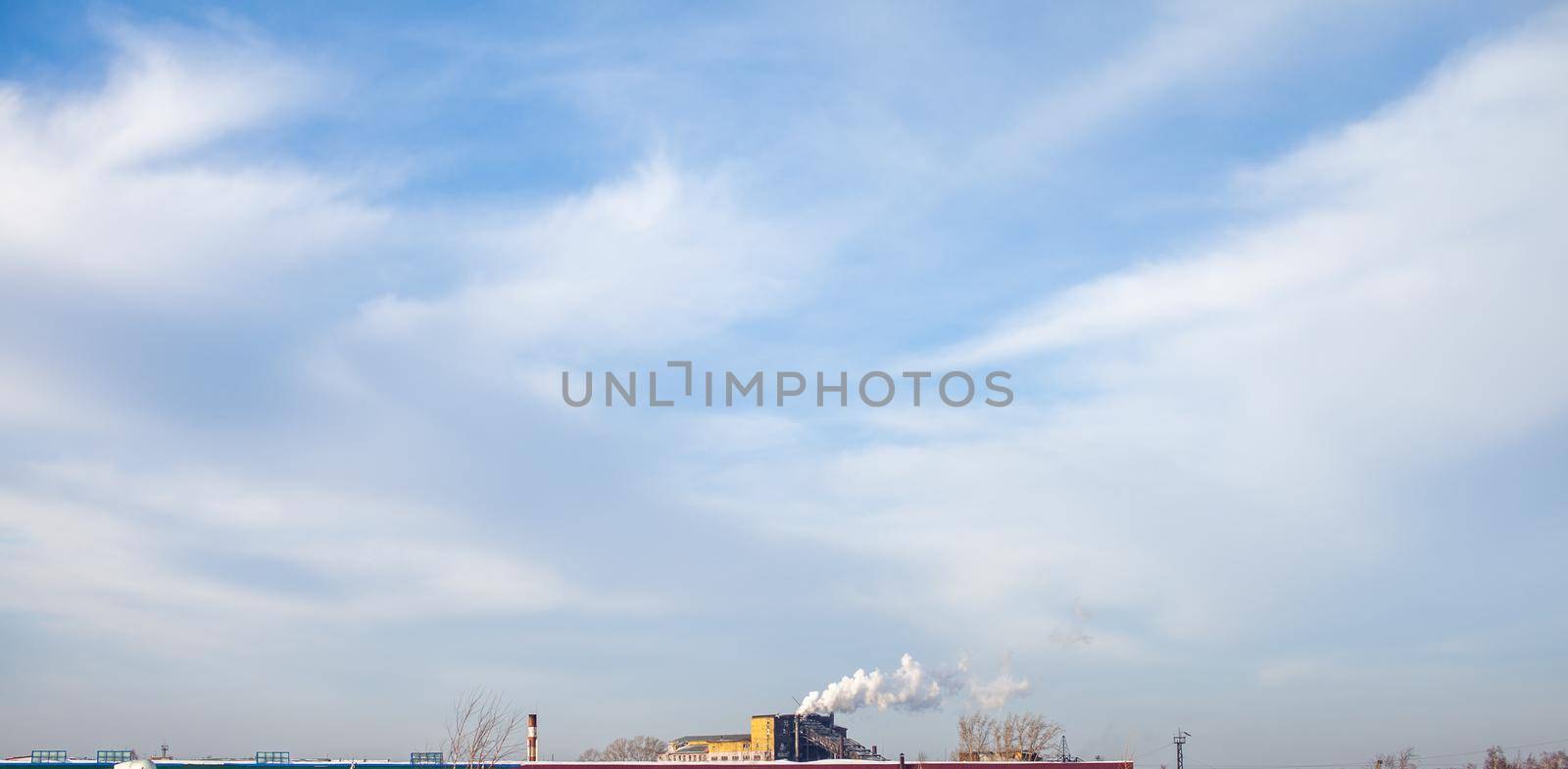 White thick smoke from the boiler room chimney. Smoke against the blue sky. Air pollution. Heating of the city. Industrial zone.