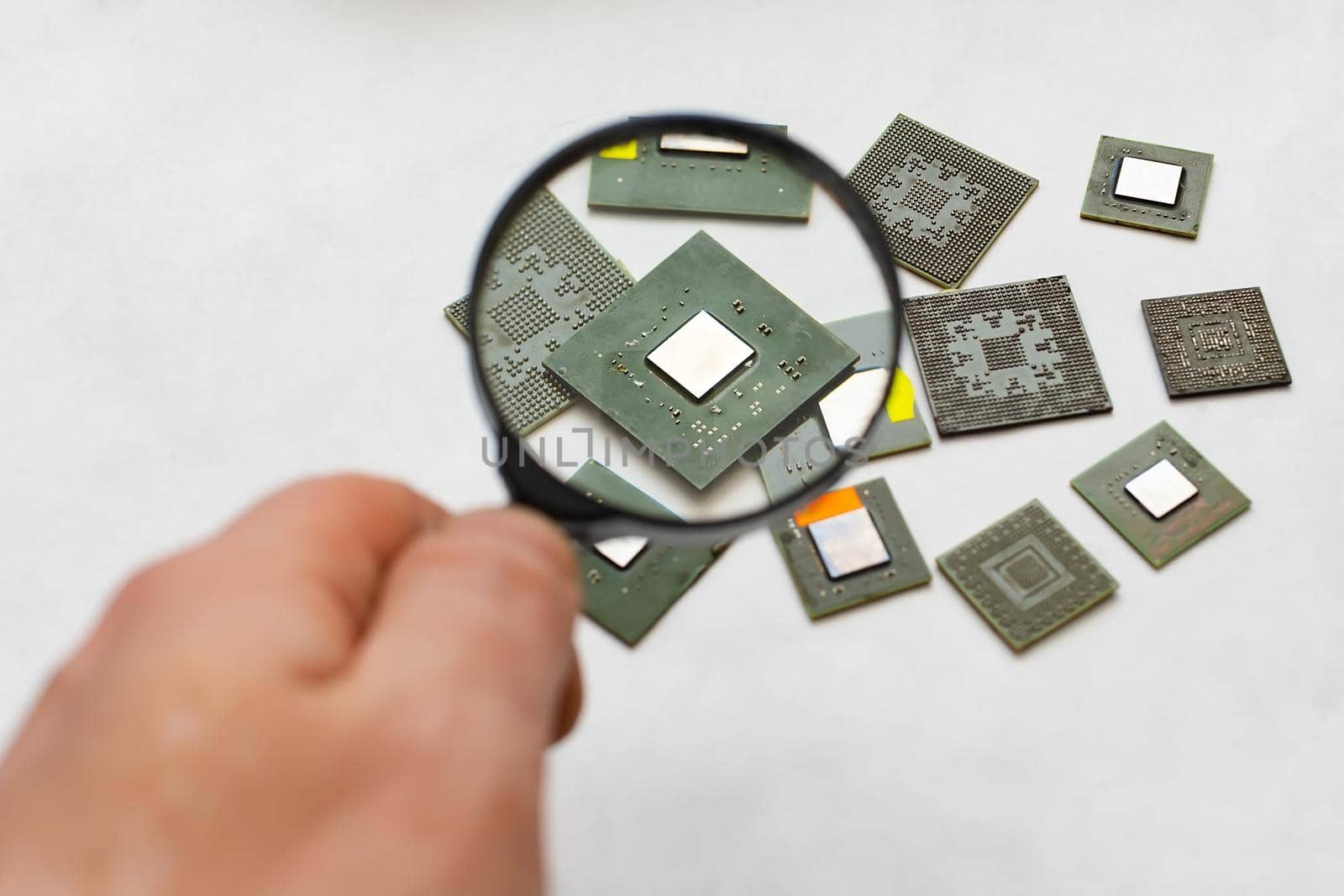 computer chip, a microprocessor that a person views through a magnifying glass by jk3030