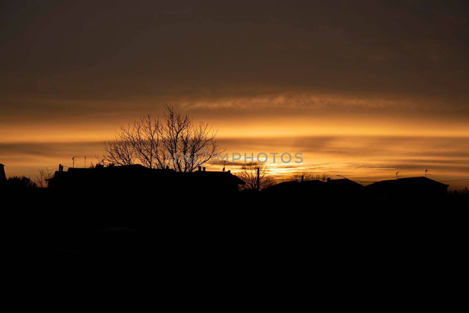 Silhouette of a Red sunset in a village during winter period