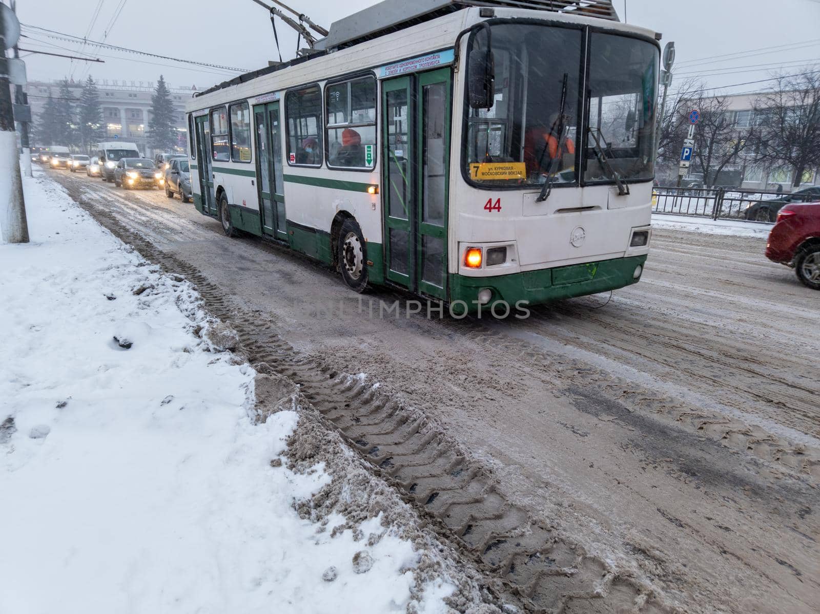 TULA, RUSSIA - NOVEMBER 21, 2020: Trolley bus arriving at station under snow on road at winter day light. by z1b