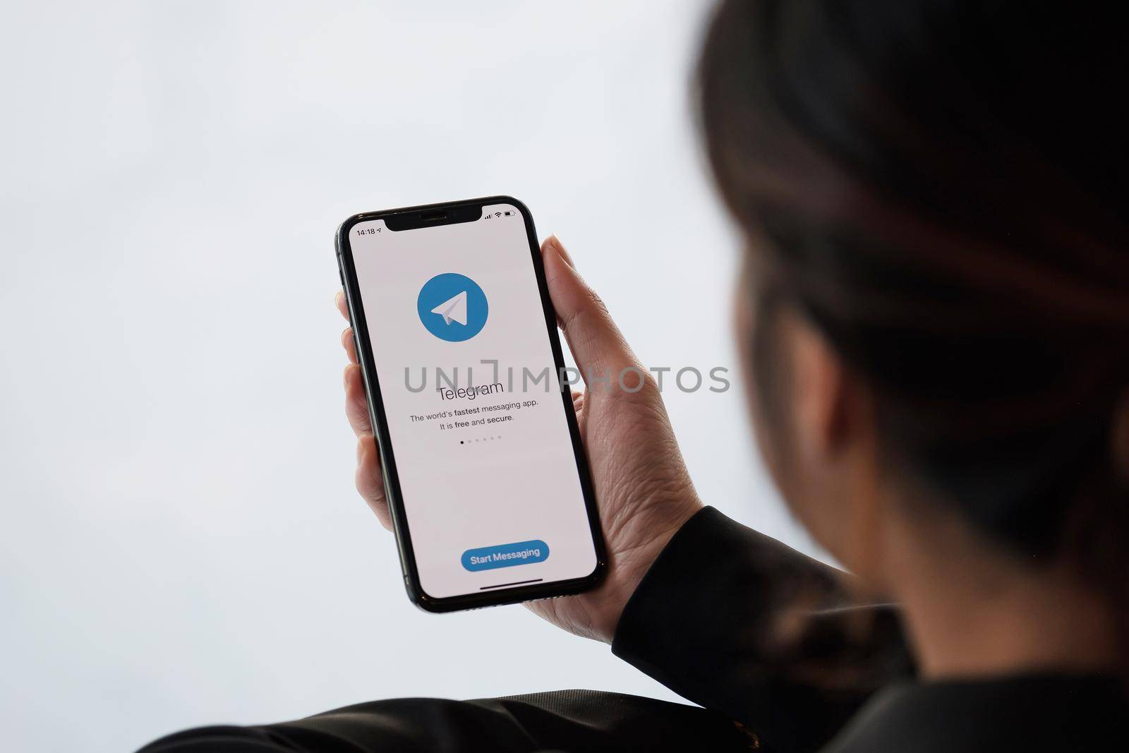 CHIANG MAI, THAILAND, JAN 18, 2021 : Woman hand holding iPhone 12 with social networking service Telegram on the screen. iPhone 12 was created and developed by the Apple inc.