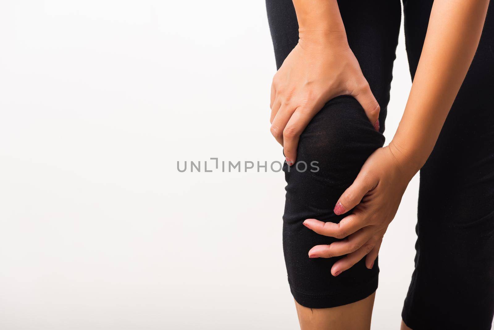 Closeup young woman aches to suffer from pain knee and she uses hand joint hold knee agony, studio shot isolated on white background Rheumatism healthcare and medical physiotherapy therapy concept