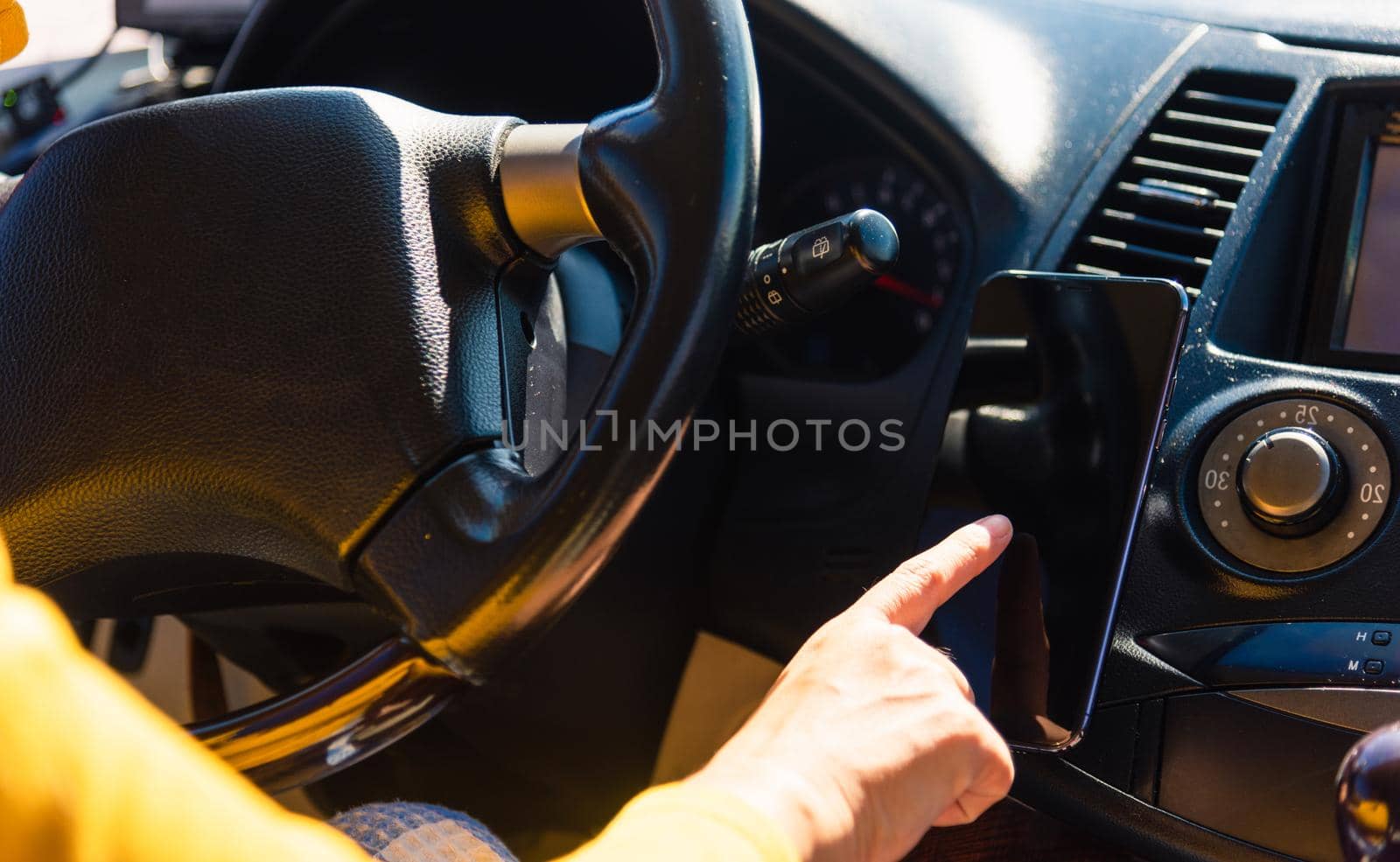 woman inside a car and using touch screen on mobile smartphone by Sorapop
