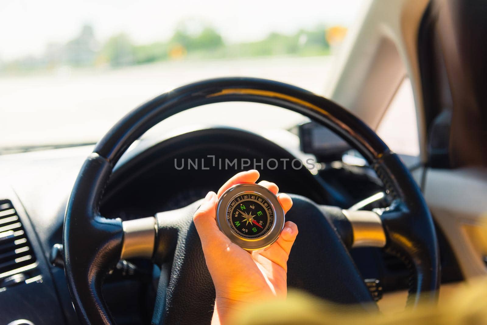 Asian woman inside a car and using compass to navigate while driving the car she find navigation location to go, Transportation and vehicle concept