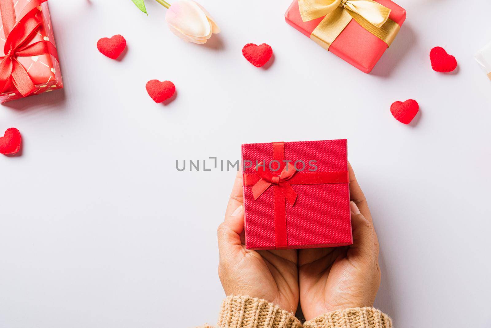 Woman hands holding gift or present box decorated and red heart surprise by Sorapop