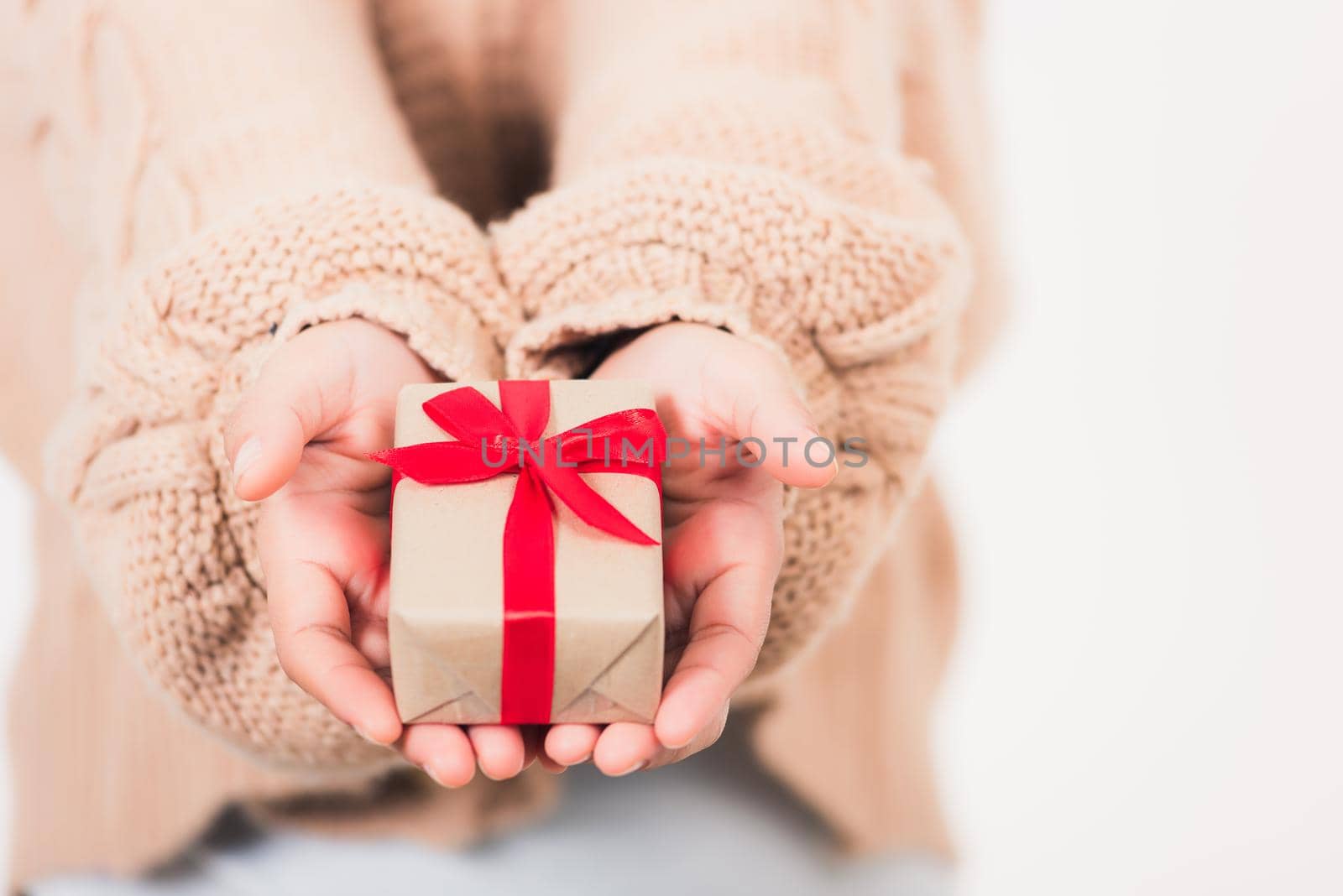 Valentine's Day. Woman beauty hands holding small gift package box present wrapped paper with ribbon isolated on white background, Birthday, New year, Christmas, holiday background concept