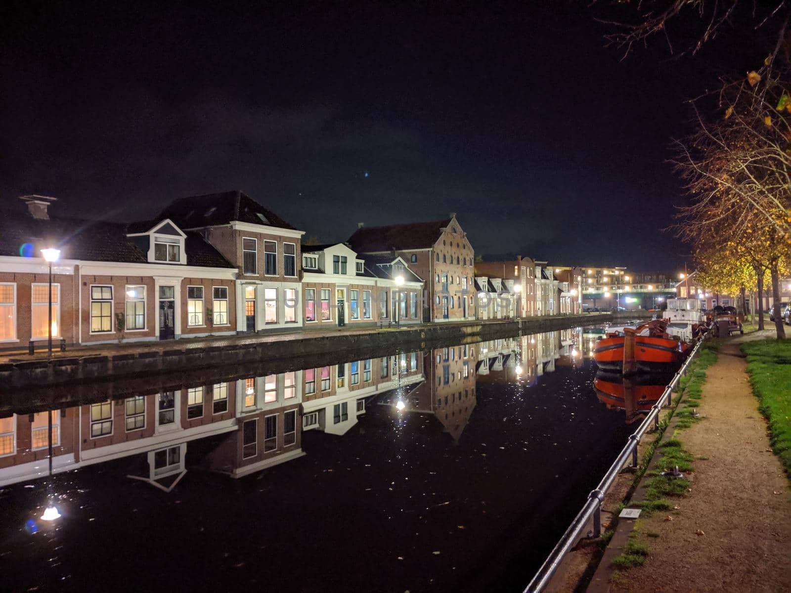 Housing along the canal at night in Sneek by traveltelly