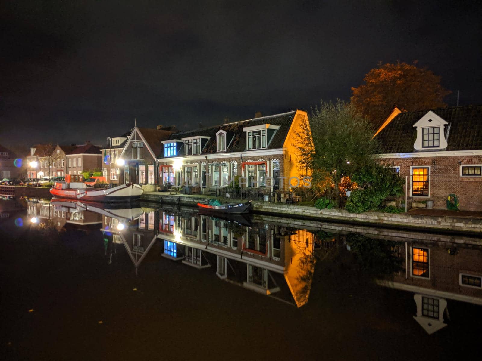 Housing along the canal at night in Sneek by traveltelly