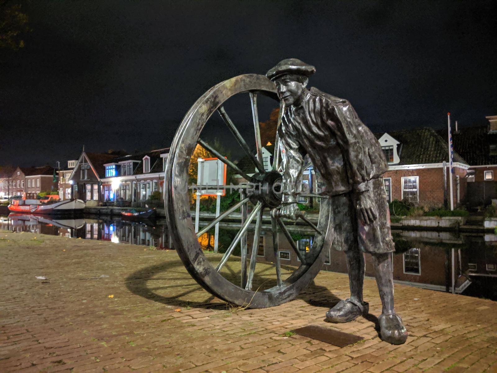 Statue along the canal at night in Sneek, Friesland, The Netherlands