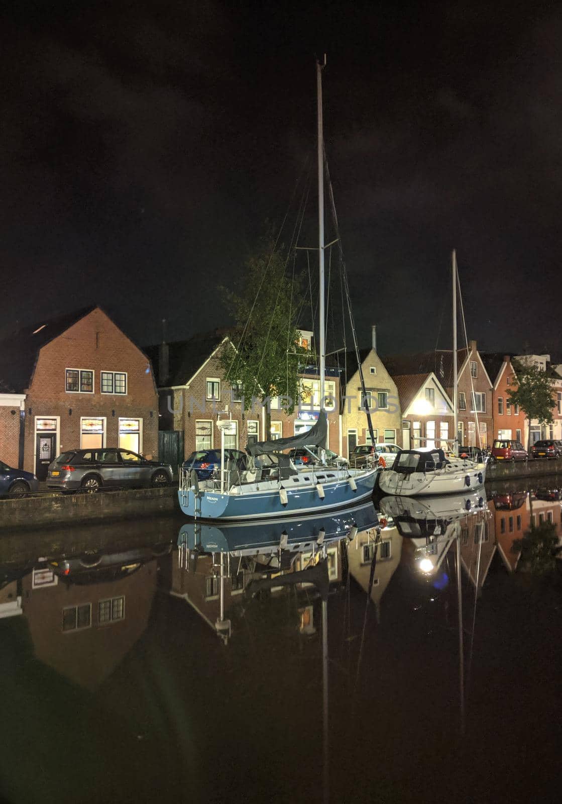 Sailboats along the canal at night in Sneek by traveltelly