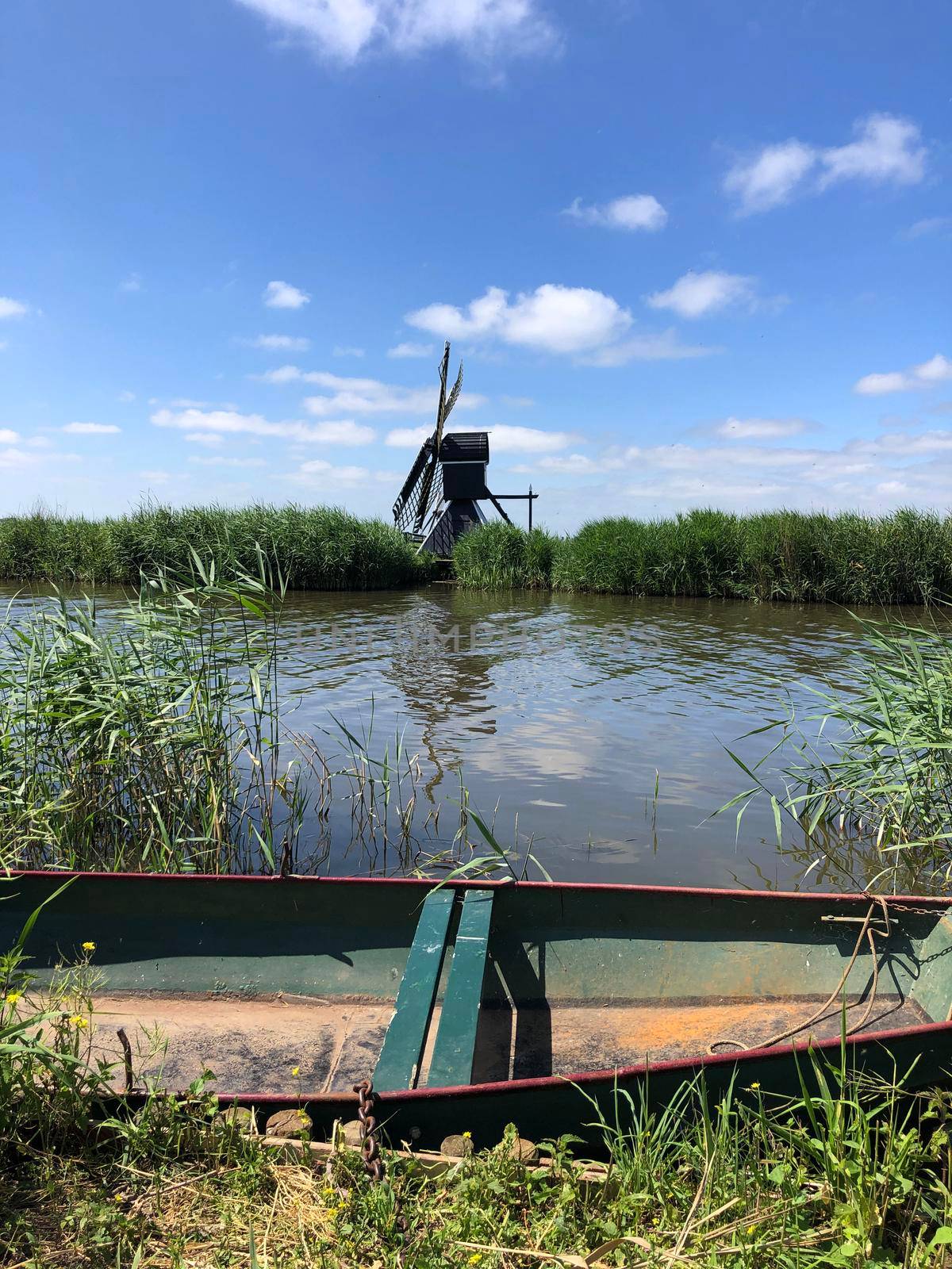 Windmill and a boat in Friesland by traveltelly
