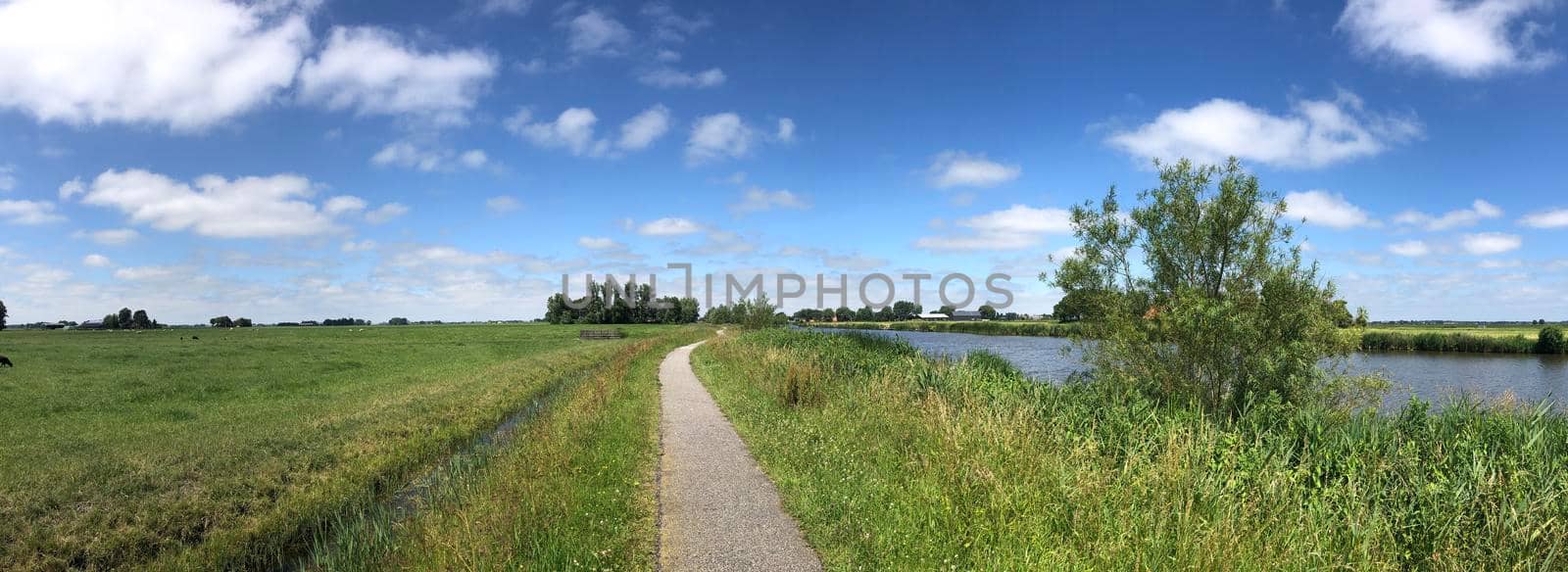 Bicycle path next to the Dokkumer Ee canal  by traveltelly
