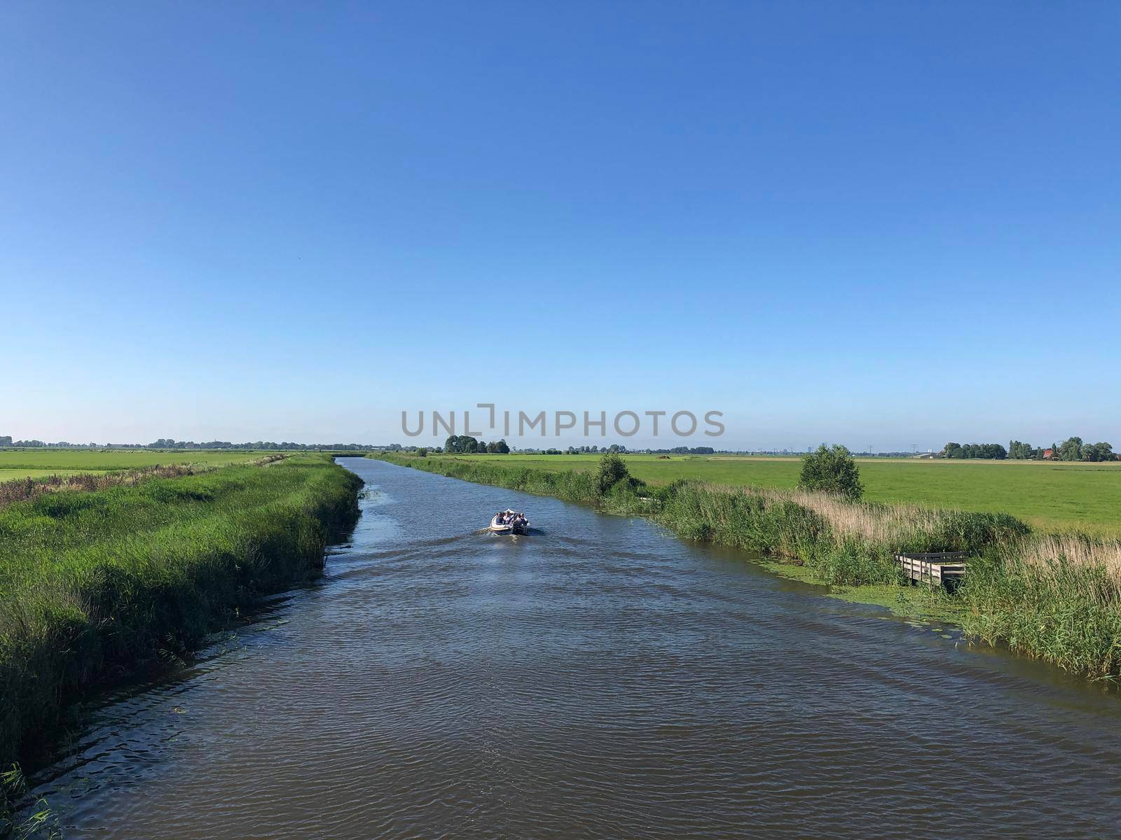 Boat on a canal in Friesland by traveltelly