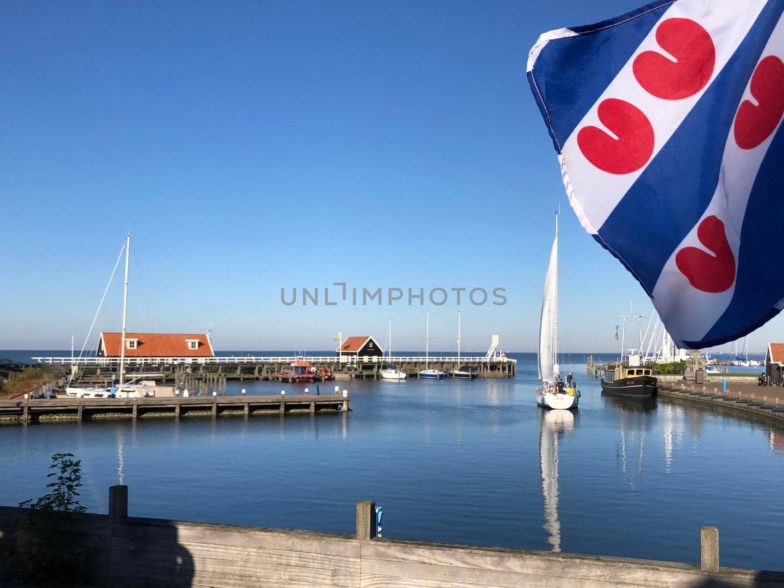 Frisian flag at the harbor in Hindeloopen during autumn in Friesland, The Netherlands