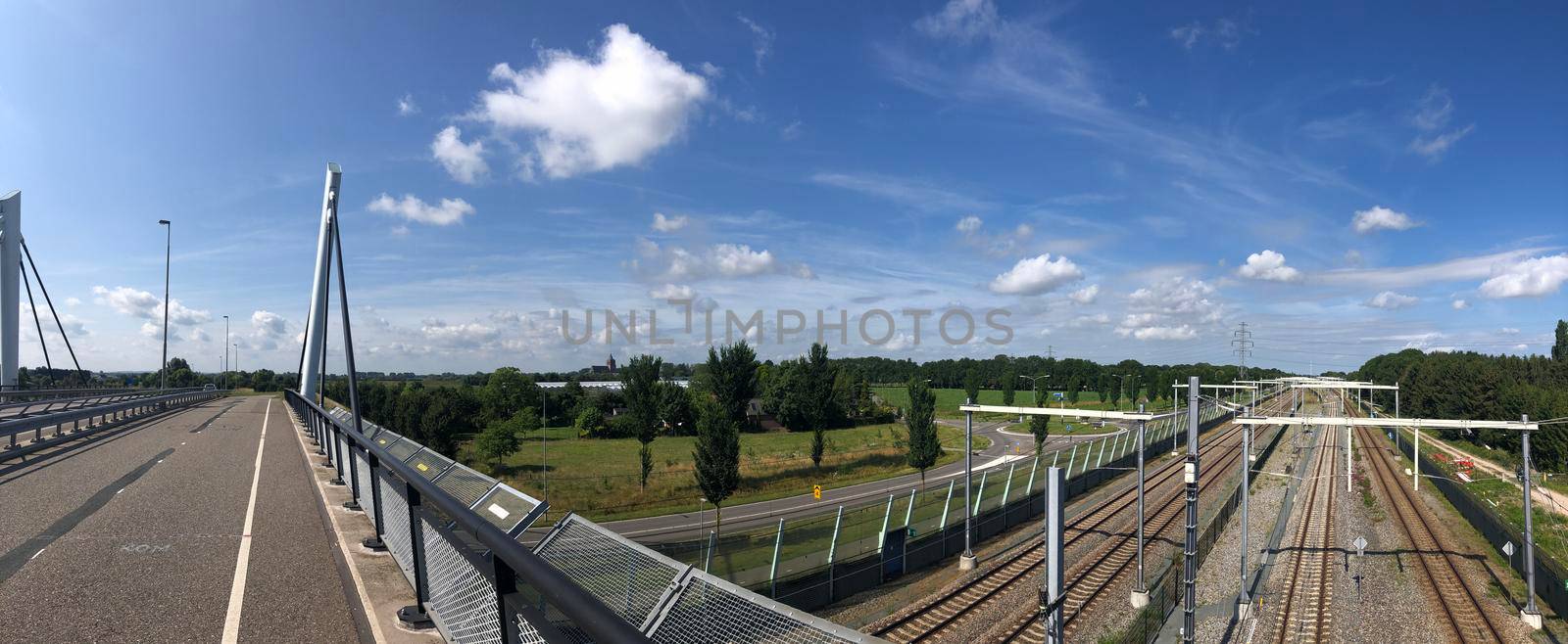 Panorama from a bridge over a train track in Zevenaar by traveltelly