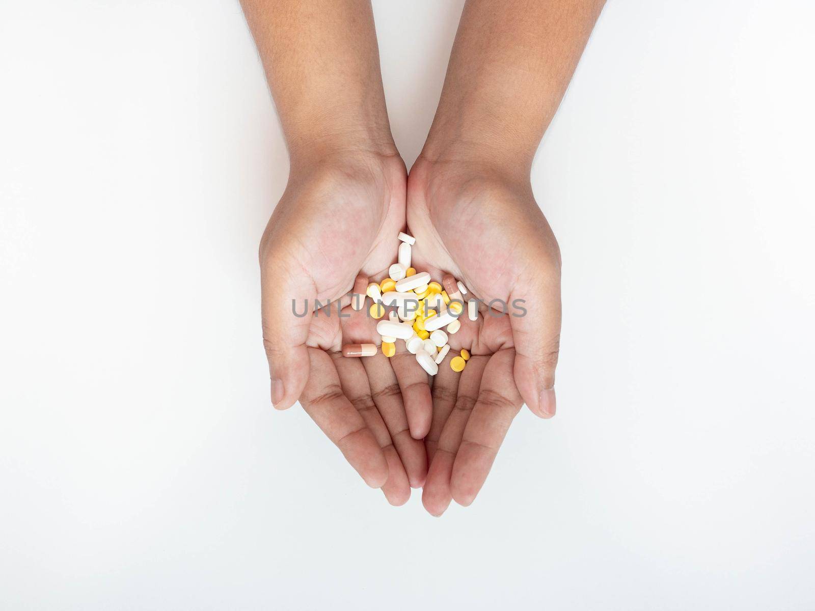 Colorful pills on hand On a white background by Kulpreya