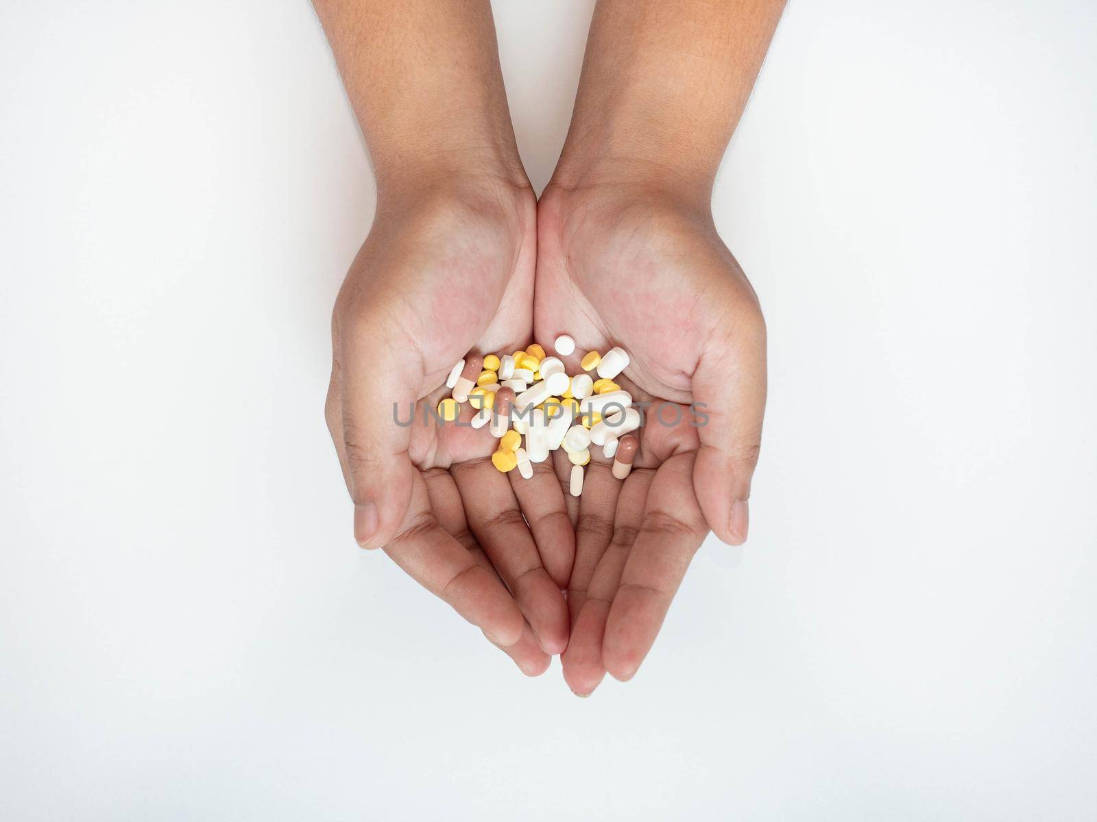 Colorful pills on hand On a white background