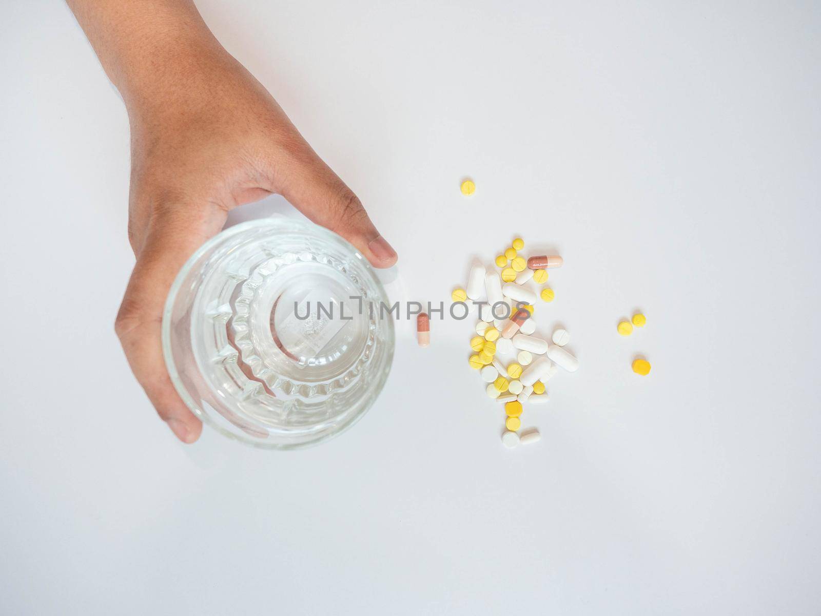 A woman with her hand on the drug The other hand was picking up a glass of water. by Kulpreya