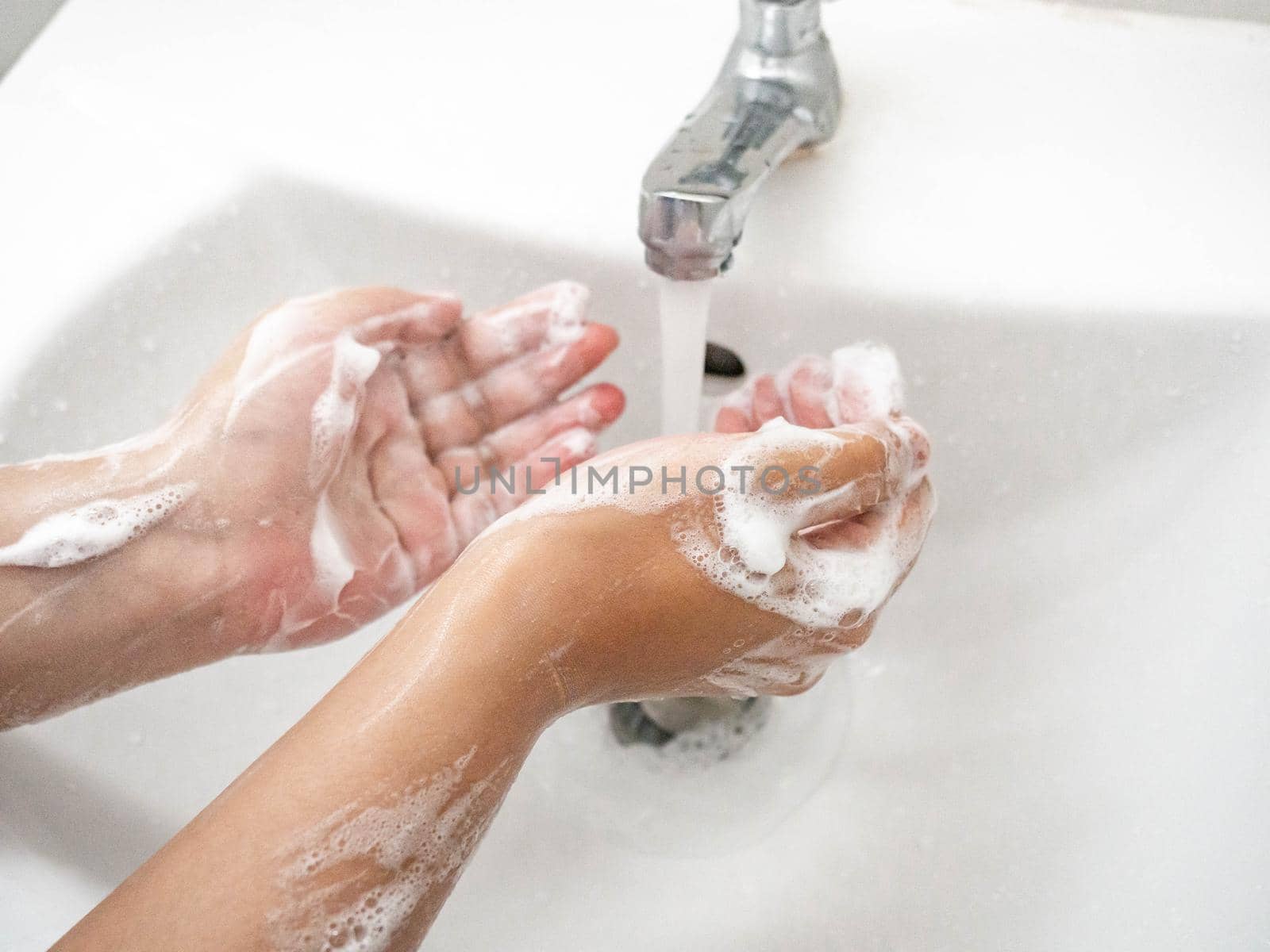 A woman cleaning hands Use hand soap until white bubbles form in the basin. by Kulpreya