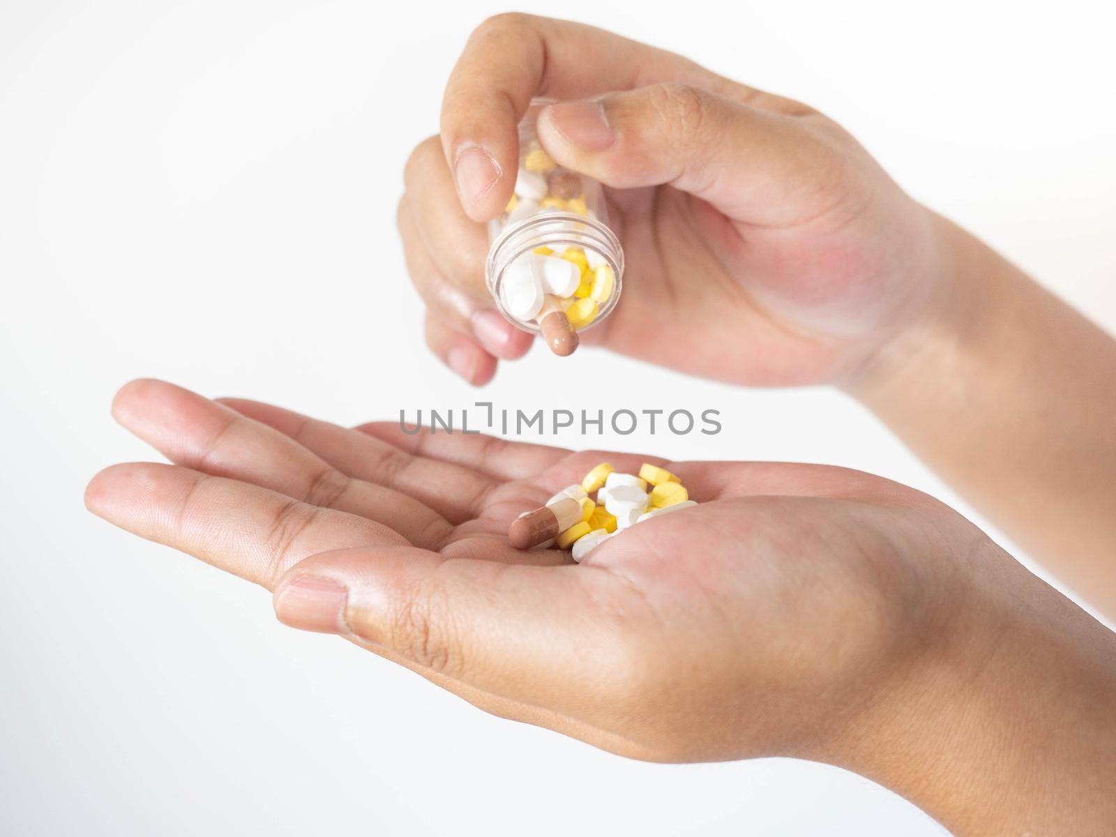 A woman pouring medicine onto her hand from a bottle On a white background