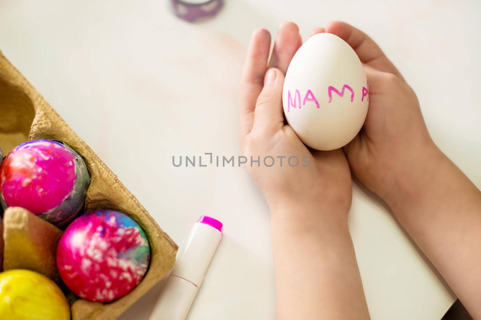 Easter egg with the inscription mom in the hands of a little girl. by galinasharapova