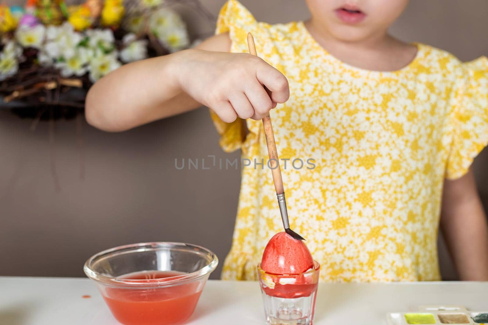 Cropped shot of adorable little girl painting egg for Easter by galinasharapova