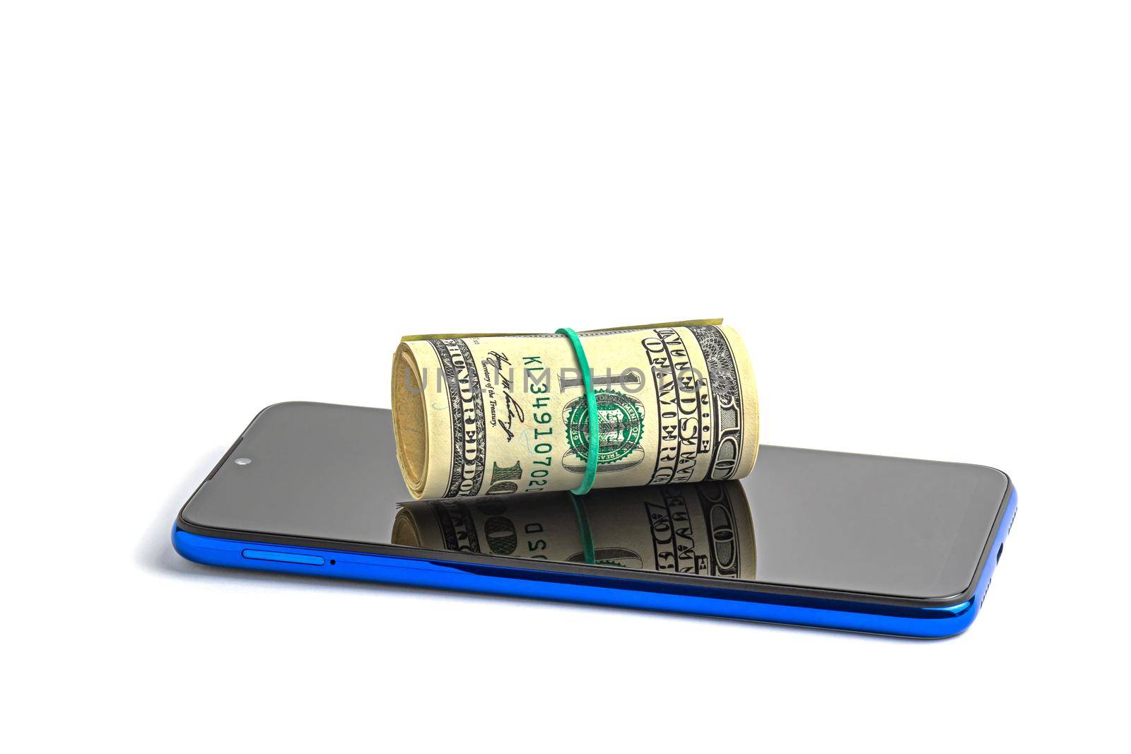 Money in a roll, tied with an elastic band, on the phone. The isolated object on a white background with a shadow. U.S. dollars. Phone and dollars isolated on white.