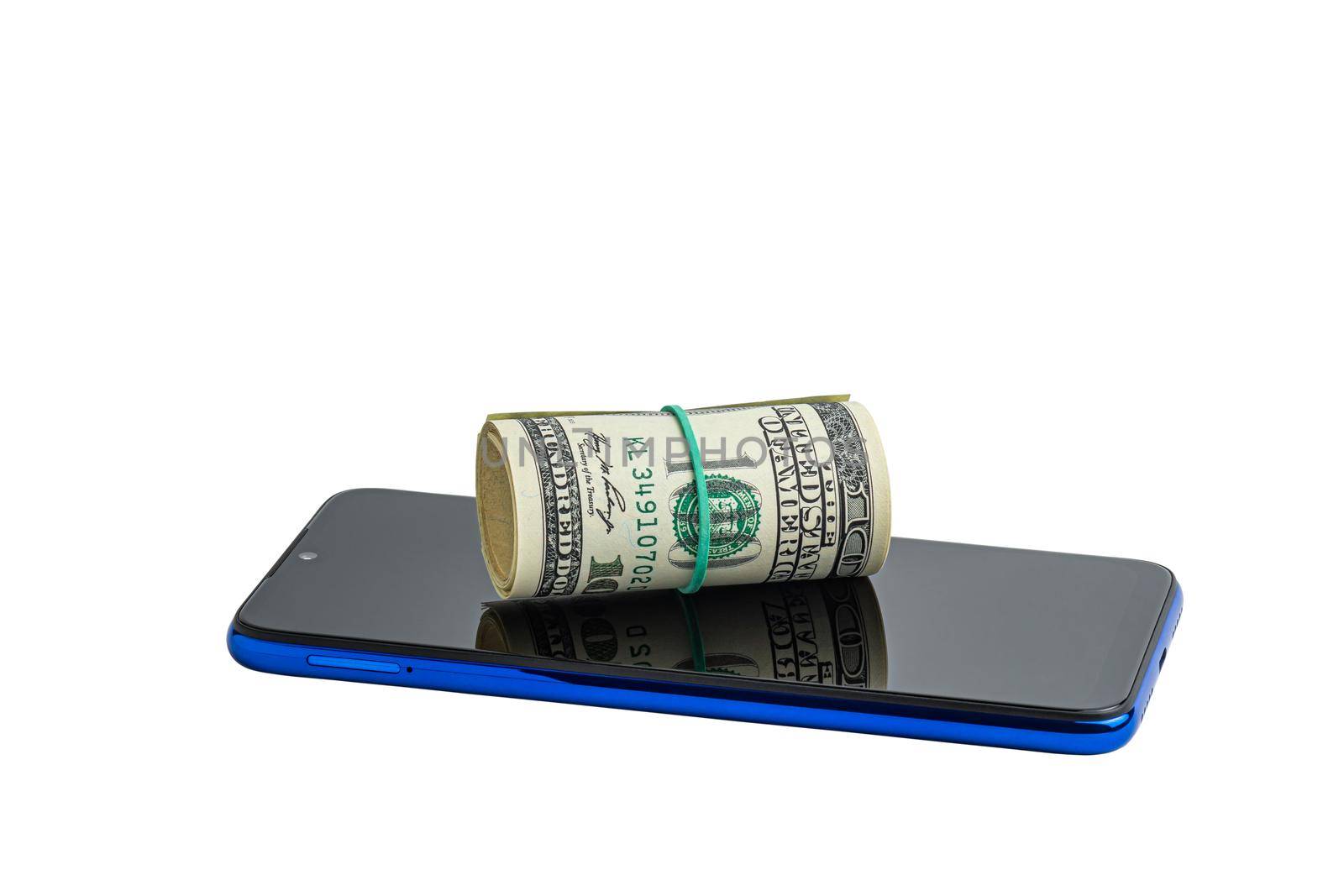 Money in a roll, tied with an elastic band, on the phone. The isolated object on a white background. U.S. dollars. Phone and dollars isolated on white.