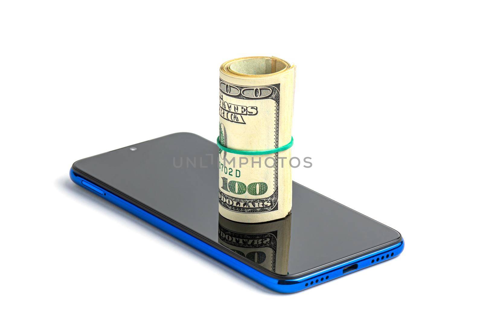 Money in a roll, tied with an elastic band, on the phone. The isolated object on a white background with a shadow. U.S. dollars. Phone and dollars isolated on white.