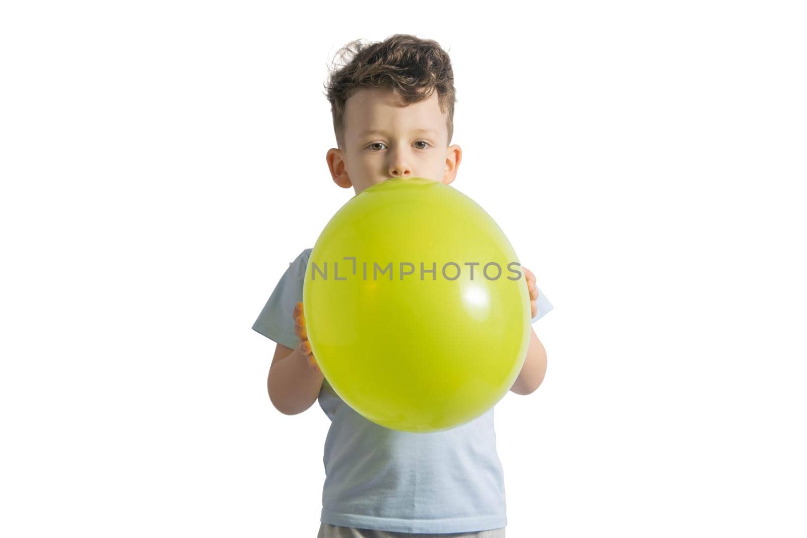 Funny boy blowing up a yellow balloon isolated on white background.