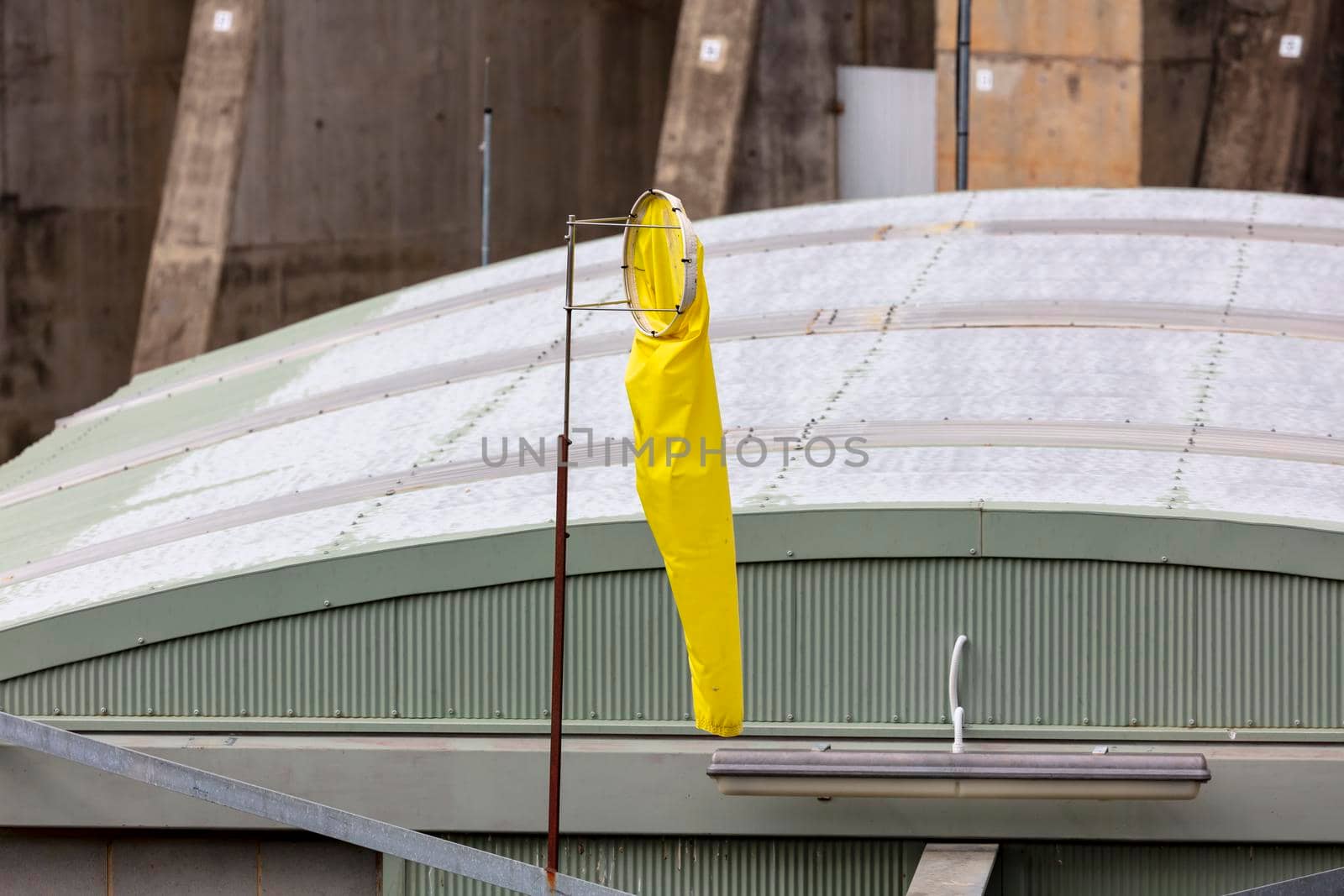 A yellow wind sock near a large building by WittkePhotos
