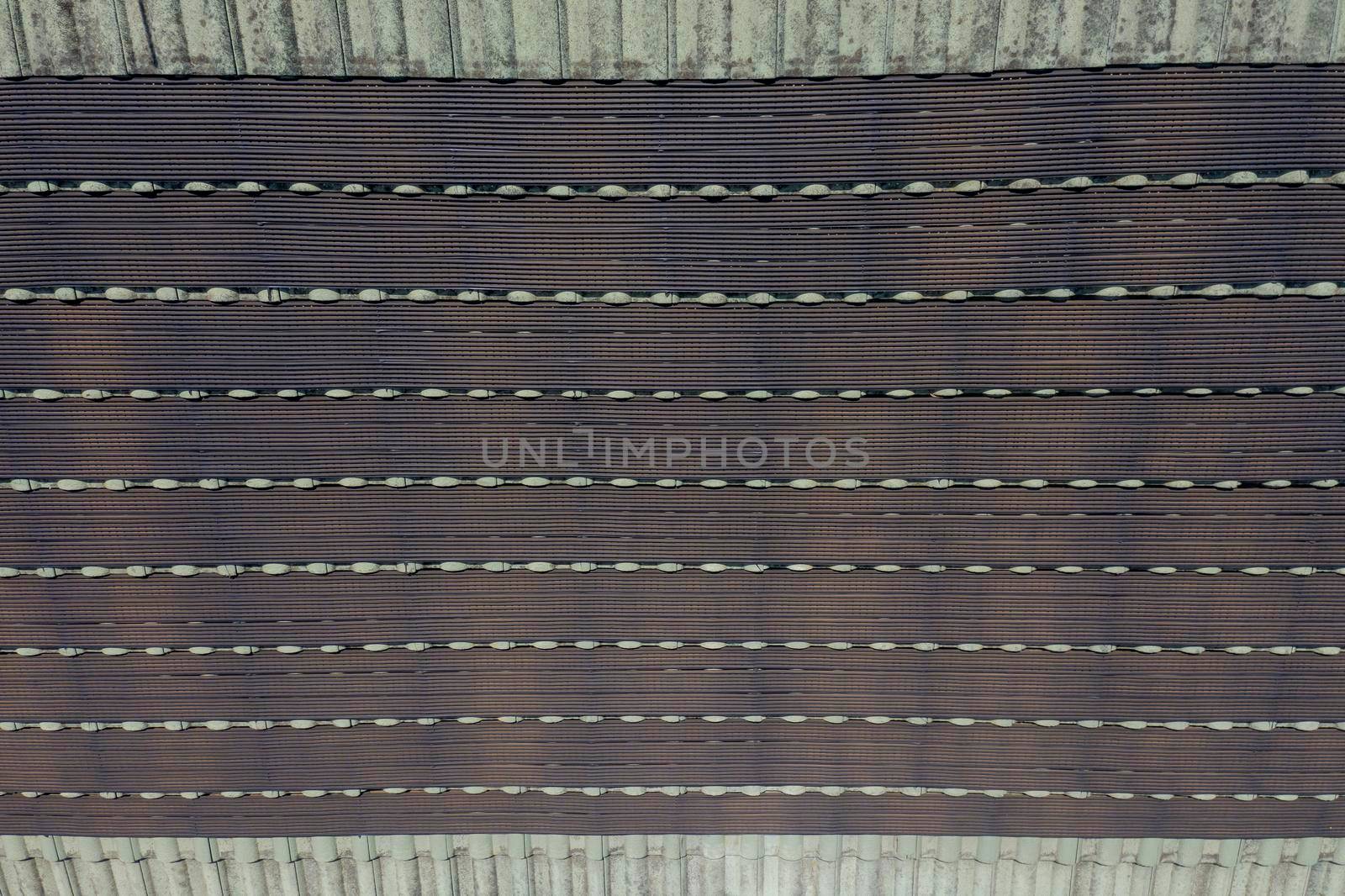 Hot water pipes on a green tiled roof in the bright sunshine. by WittkePhotos