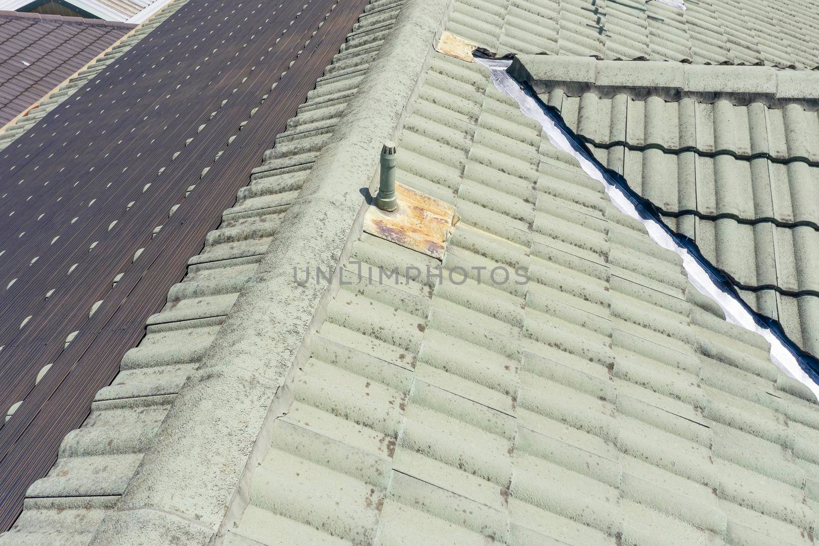 Hot water pipes on a green tiled roof in the bright sunshine.