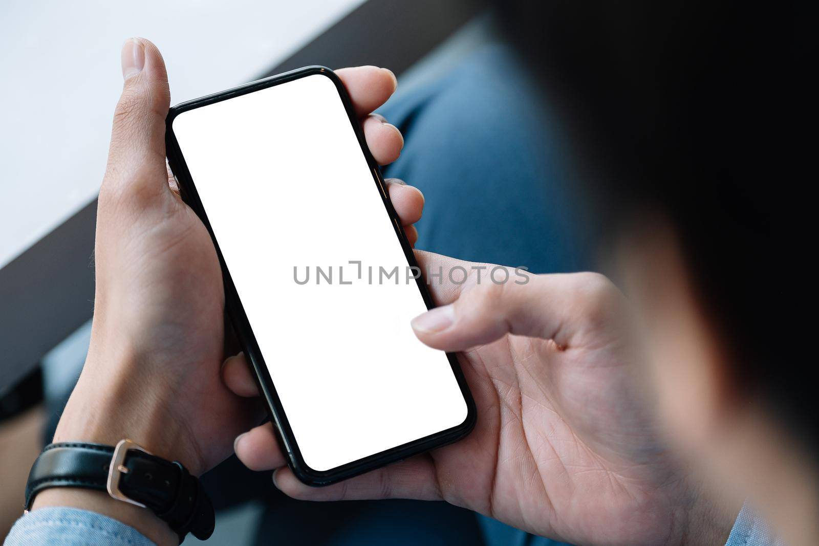 Top view Businessman sitting and holding blank screen mock up mobile phone..