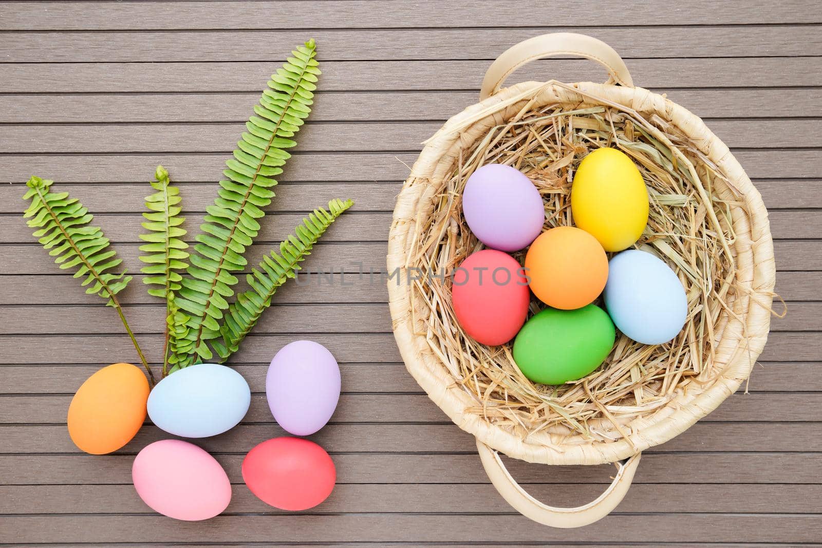 Close up Colorful easter eggs in the basket on wood background with space