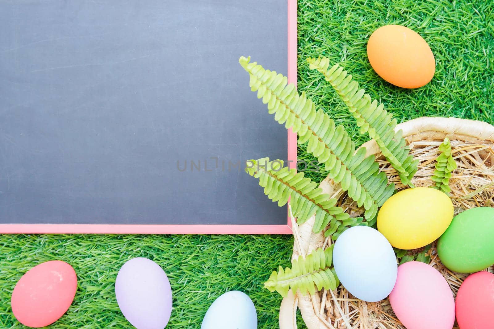 Close up Easter eggs on grass and blackboard mockup by stoonn