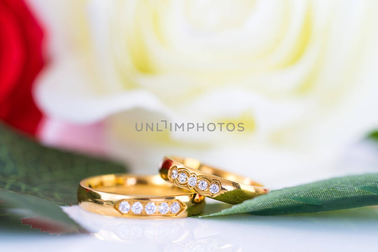 Close up Gold ring and Red roses on white  by stoonn