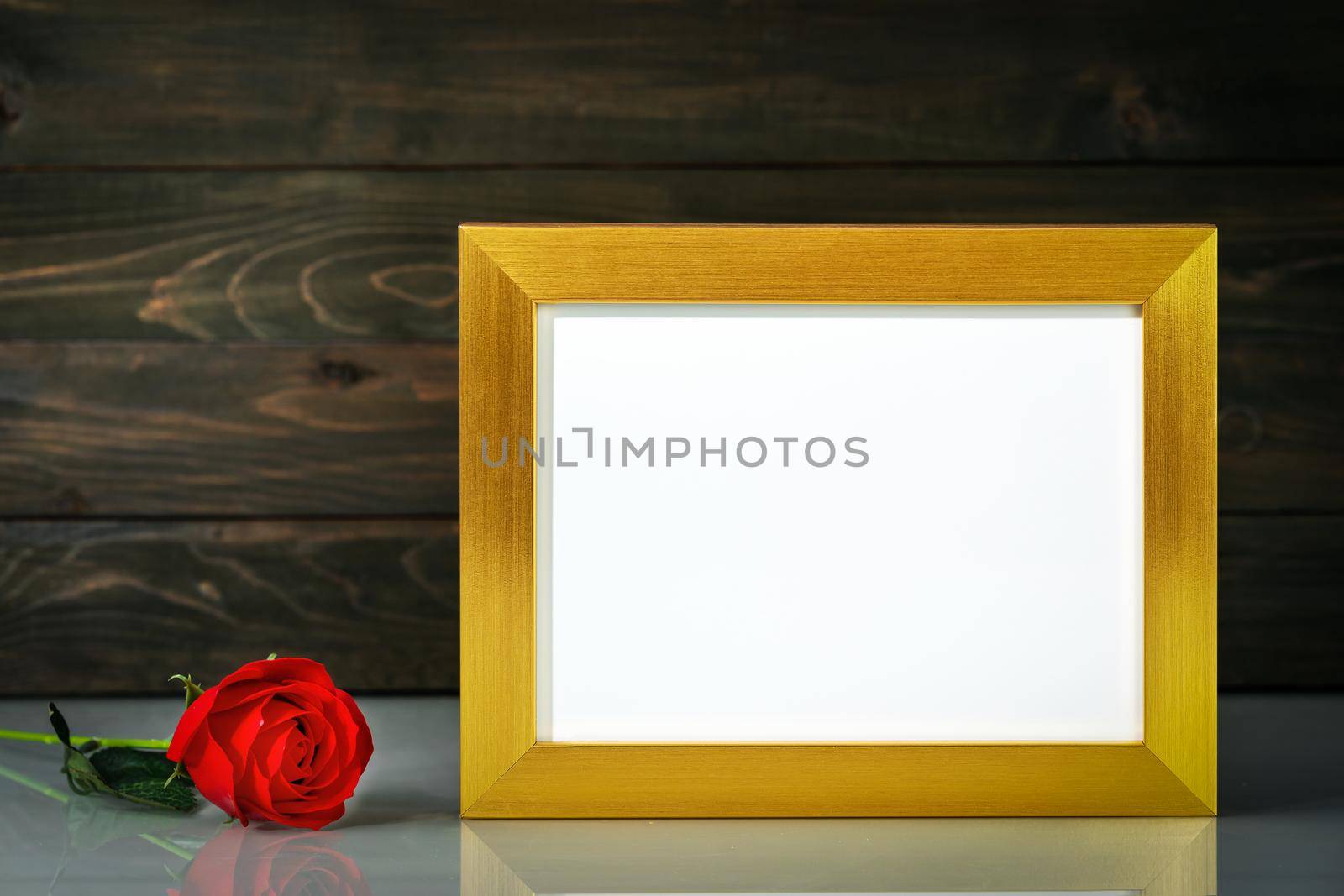 Picture mock up with golden frame and red roses flowers on table with copy space