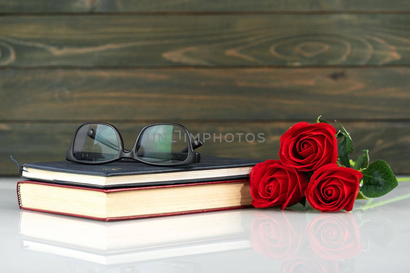 Red roses on table and book with copy space, Valentine's day background with red roses