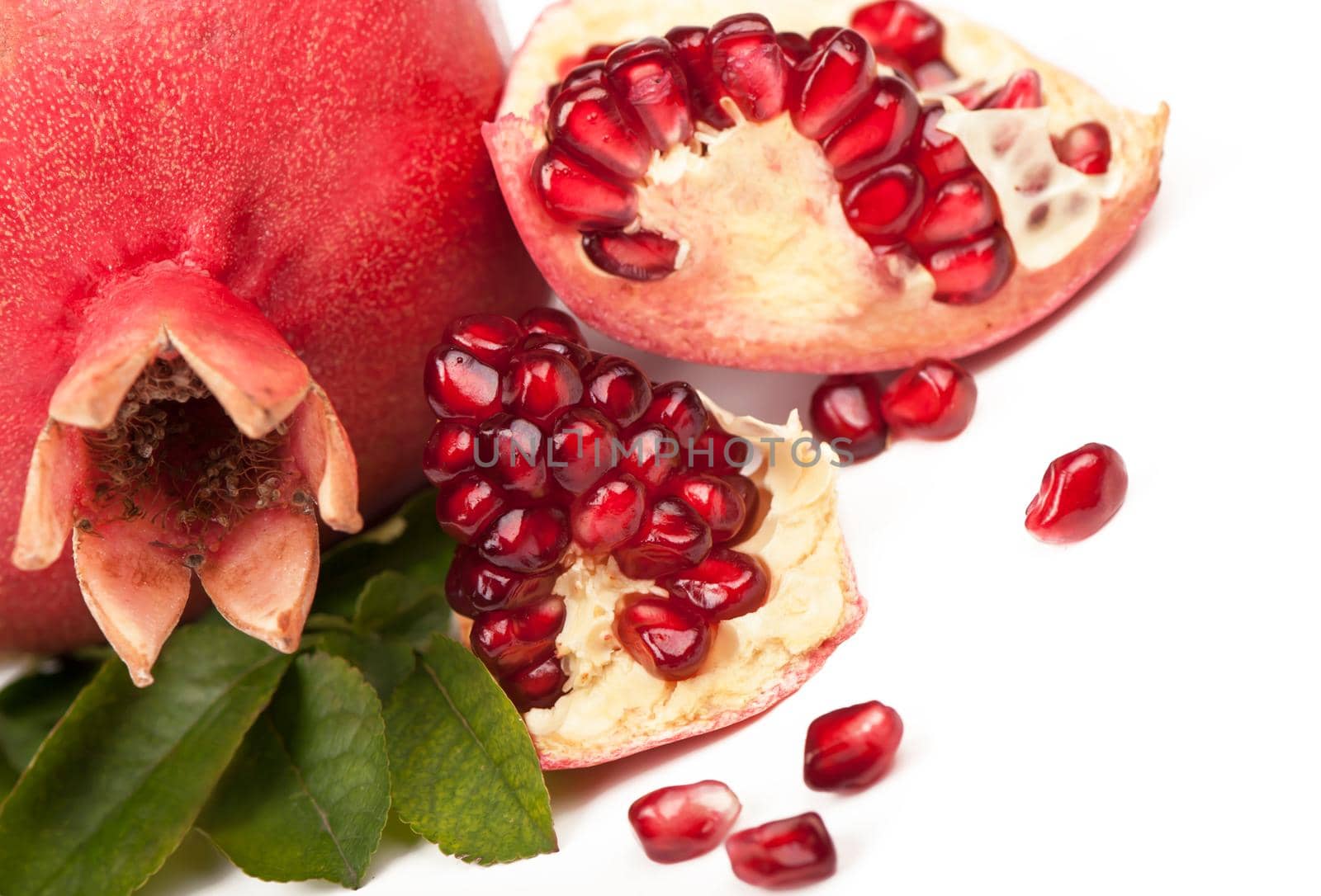 ripe pomegranate with leaves on a wooden board by aprilphoto