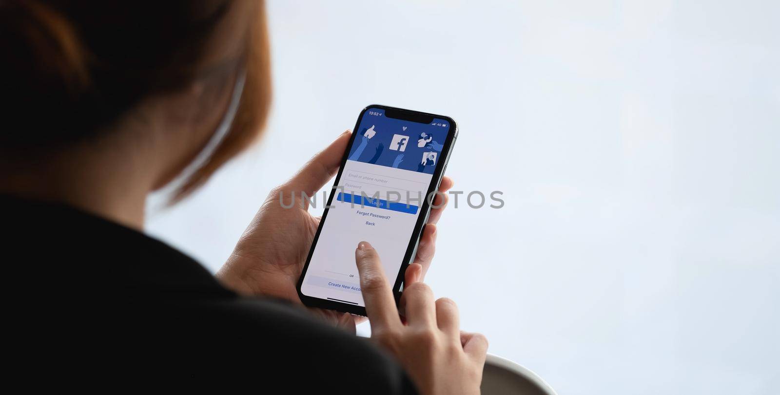 CHIANG MAI, THAILAND - JAN 17, 2021 : Facebook social media app logo on log-in, sign-up registration page on mobile app screen on iPhone X in person's hand working on e-commerce shopping business