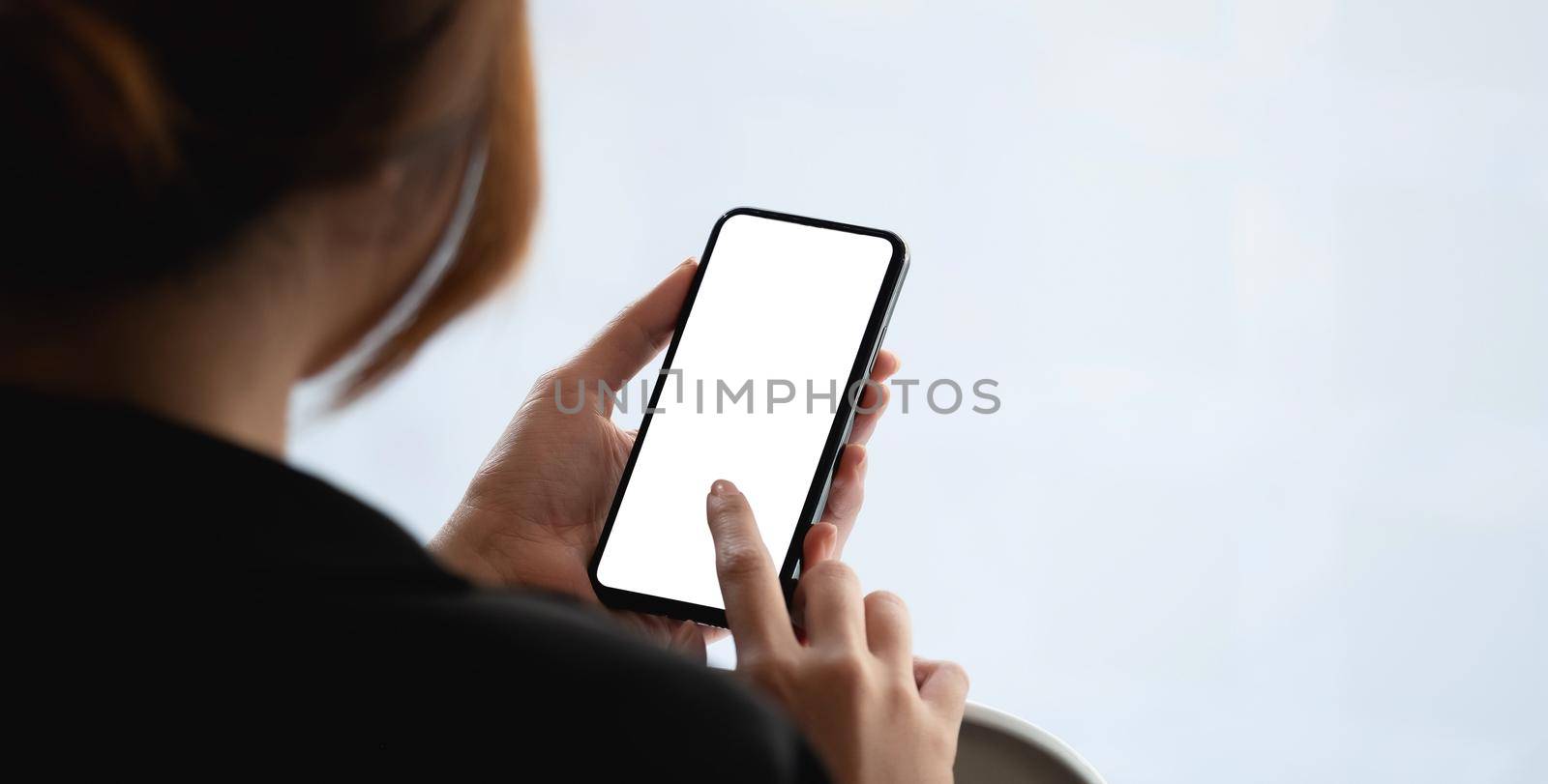 Top view Businessman sitting and holding blank screen mock up mobile phone. by nateemee