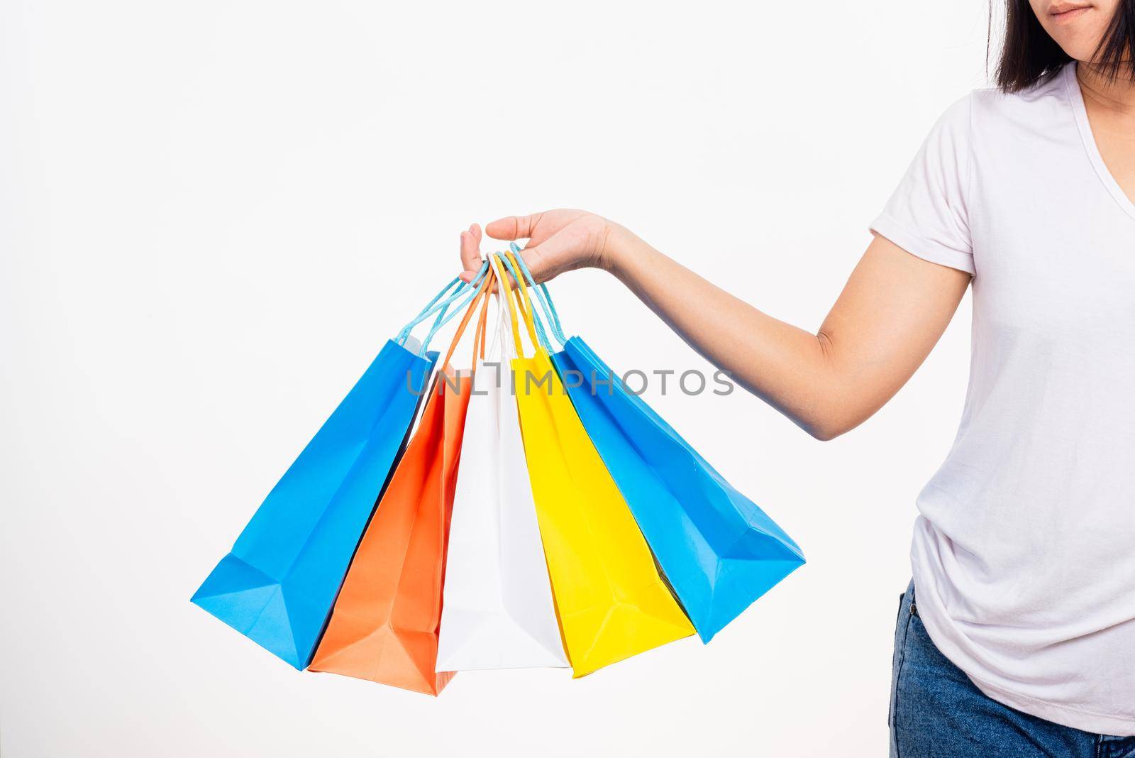 Happy woman hand holding shopping bags multicolor, young female hold many packets within arms isolated on white background, Black friday sale concept