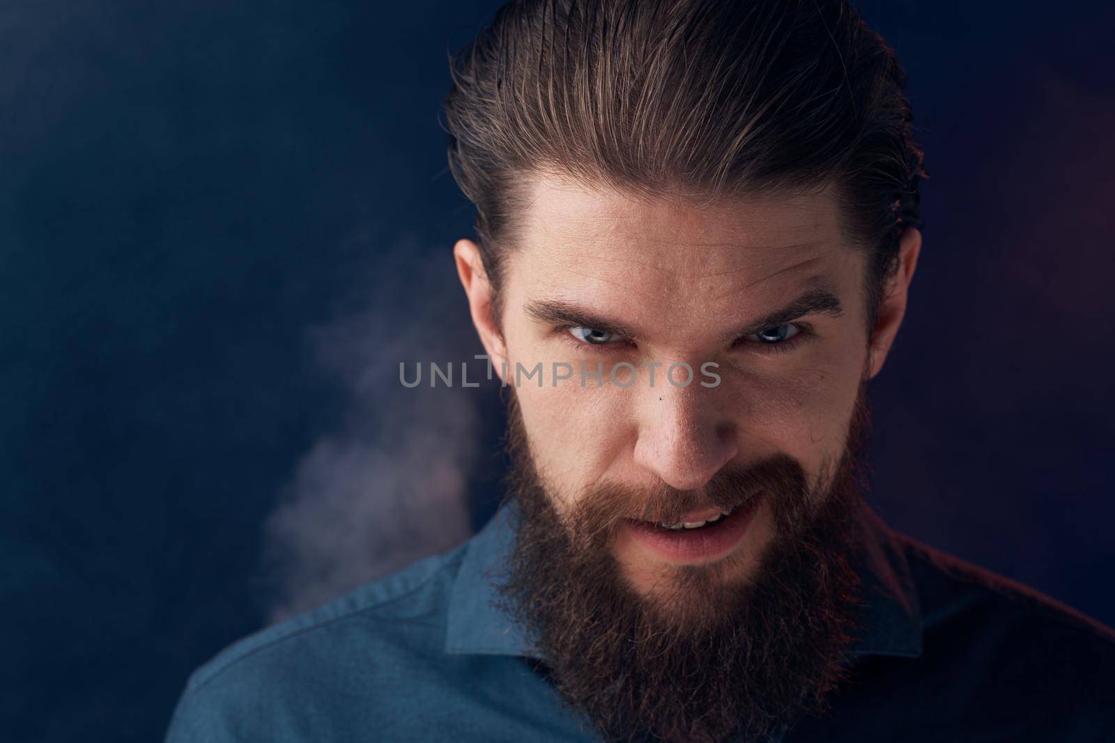 Emotional man black shirt attractive look close-up smoke in the background. High quality photo